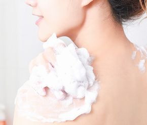 コラージュフルフル泡石鹸で体を洗う女性