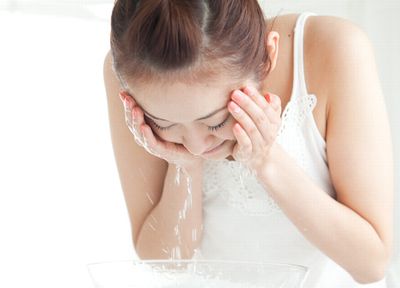 ぬるま湯で洗顔する女性