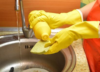手袋をはいて食器洗いする女性